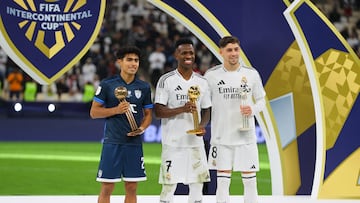 Soccer Football - Intercontinental Cup - Final - Real Madrid v Pachuca - Lusail Stadium, Lusail, Qatar - December 18, 2024 Real Madrid's Vinicius Junior poses with the golden ball award on the podium alongside silver ball award winner Real Madrid's Federico Valverde and bronze ball award Pachuca's Elias Montiel REUTERS/Ibraheem Al Omari