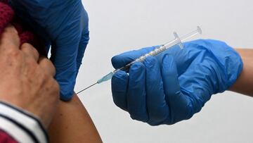 (FILES) In this file photo taken on November 30, 2021 a doctor vaccinates a patient against Covid-19 at a vaccination center in Sonthofen, southern Germany, amid the ongoing coronavirus (Covid-19) pandemic. - Germany's parliament on April 7, 2022 rejected a government-backed proposal for mandatory Covid vaccines for people above 60, in a stinging defeat for Chancellor Scholz's coalition. (Photo by Christof STACHE / AFP)