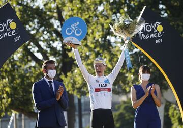 El ciclista de los Emiratos Árabes Unidos Tadej Pogacar de Eslovenia celebra en el podio tras ganar el maillot blanco y el Tour de Francia