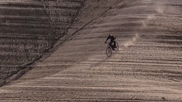 El piloto de MTB Kilian Bron bajando con su bici por una monta&ntilde;a con texturas en los Pirineos. 