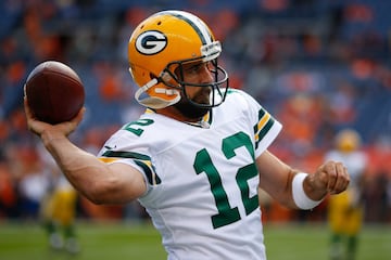 El quarterback Aaron Rodgers (12), de los Green Bay Packers, calienta el brazo previo al juego ante los Denver Broncos.