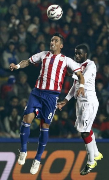 Paraguay's Lucas Barrios jumps for the ball with Peru's Christian Ramos (R) during their Copa America 2015 third-place soccer match at Estadio Municipal Alcaldesa Ester Roa Rebolledo in Concepcion, Chile, July 3, 2015. REUTERS/Mariana Bazo