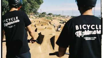 Dos pilotos de MTB se miran una de las líneas de Dirt Jump de La Poma Bikepark (Premià de Dalt, Barcelona), en un día soleado.