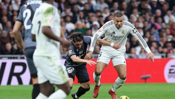 Rayo Vallecano's Uruguayan defender #22 Alfonso Espino and Real Madrid's French forward #09 Kylian Mbappe (R) fight for the ball during the Spanish league football match between Real Madrid CF and Rayo Vallecano de Madrid at the Santiago Bernabeu stadium in Madrid on March 9, 2025. (Photo by Thomas COEX / AFP)