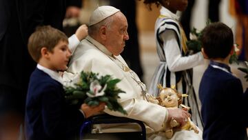 Pope Francis holds a figure of baby Jesus during celebration of Christmas Eve mass in St. Peter's Basilica at the Vatican, December 24, 2023. REUTERS/Remo Casilli