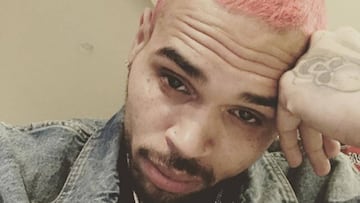 El rapero Chris Brown con el pelo te&ntilde;ido de color rosa y el rostro serio