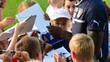 Balotelli firma autógrafos a varios niños tras un entrenamiento.