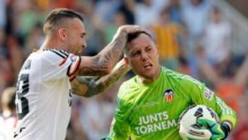 El portero brasileño del Valencia Diego Alves (d) es felicitado por su compañero, el defensa argentino Nicolás Otamendi (i), tras parar el penalti lanzado por el defensa brasileño del Atlético de Madrid, Guilherme Siqueira.