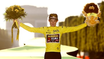 Jonas Vingegaard celebra su victoria en el Tour de Francia en el podio de París, con el Arco del Triunfo al fondo.