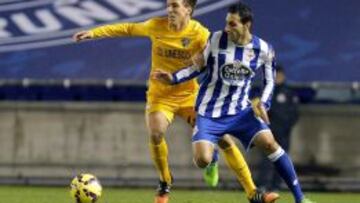 El centrocampista del Málaga, Camacho, disputa un balón con el jugador del Deportivo de la Coruña, José Rodriguez, durante el encuentro correspondiente a la jornada catorce de primera división, que disputan esta noche en el estadio de Riazor, en A Coruña.