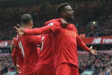 Liverpool's Belgian striker Divock Origi (R) celebrates with teammates after scoring their third goal during the English Premier League football match between Liverpool and Everton at Anfield