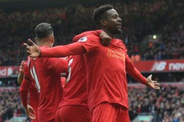 Liverpool's Belgian striker Divock Origi (R) celebrates with teammates after scoring their third goal during the English Premier League football match between Liverpool and Everton at Anfield 