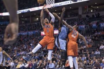 Russell Westbrook lanza junto a Kevin Durant mientras JaMychal Green intenta evitar la canasta.