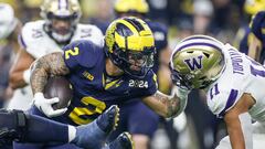 Jan 8, 2024; Houston, TX, USA; Michigan running back Blake Corum runs against Washington linebacker Alphonzo Tuputala during the first half of the CFP college football national championship game at NRG Stadium in Houston, Texas on Monday, Jan. 8, 2024. Mandatory Credit: Junfu Han-USA TODAY Sports