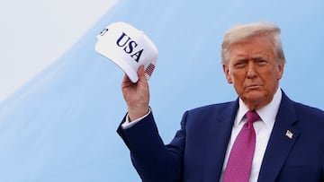 Donald Trump sostiene una gorra de Estados Unidos al desembarcar del Air Force One en Carolina del Norte.