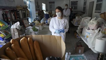 Imagen de una trabajadora en situación de ERTE que se encuentra colaborando como voluntaria en el reparto de alimentos de una asociación.