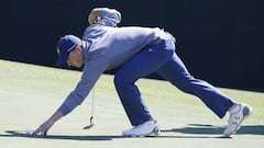 Jordan Spieth of the US picks up his ball on the fifth hole during the third round of the 2016 Masters Tournament at the Augusta National.