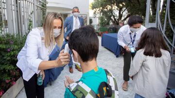 GRAF8039. BARCELONA, 01/09/2020.- Una trabajadora toma la temperatura a un niño a la entrada del colegio privado internacional American School of Barcelona, situado en Esplugues de Llobregat (Barcelona), este lunes. Este colegio, con 890 alumnos, es el primero en España que inicia el curso con medidas anticovid. EFE/ Marta Perez