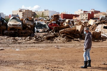 Un hombre se encuentra junto a vehículos dañados por las inundaciones mortales en Catarroja, Valencia, España.