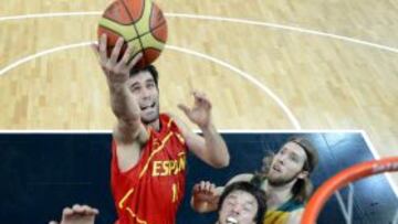 El jugador español Fernando San Emeterio entra a canasta a pesar de la defensa de los australianos Joe Ingles, Matt Dellavedova y David Barlow durante un partido de la fase de grupos del torneo olímpico de baloncesto.
