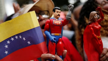 A supporter of Venezuela's President Nicolas Maduro holds an action figure of "Super Bigote" (Super Mustache), a superhero inspired by the Venezuelan President, as people attend a ceremony hosted by Maduro at Miraflores Palace to swear in new community-based organisations, as U.S. President Donald Trump’s administration ramps up pressure on Maduro’s government, in Caracas, Venezuela, December 1, 2025. REUTERS/Leonardo Fernandez Viloria