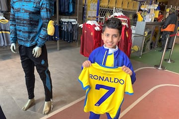 A young fan holds t-shirt with the name Ronaldo and number 7, which are flying off the shelves.