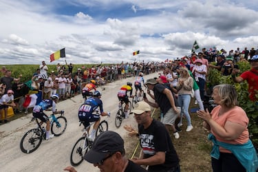 Vista general de los corredores y los aficionados aglutinados a su paso en el tramo de tierra de Baroville.