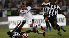 Brazil&#039;s Botafogo Jonas Silva falls on the pitch as Esteban Paredes of Chile&#039;s Colo Colo, center, and Brazil&#039;s Botafogo Airton, compete for control of the ball, during a Copa Libertadores soccer match at the Nilton Santos stadium, in Rio de