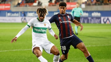 EIBAR (GIPUZKOA), 16/12/2025.- El delantero del Eibar Adu Ares (d) presiona al delantero del Elche John Donald durante el partido de dieciseisavos de final de la Copa del Rey de fútbol entre Eibar y Elche, este martes en el estadio de Ipurua. EFE/ Juan Herrero