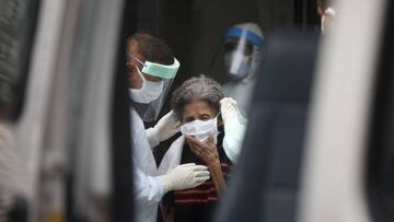 Medical staff evacuate an elderly woman from a nursing home after multiple residents of the facility tested positive for the new coronavirus, in Buenos Aires, Argentina, Wednesday, April 22, 2020. (AP Photo/Natacha Pisarenko)