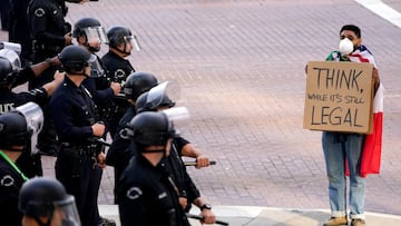 Manifestante sostiene un cartel frente a agentes de policía durante una protesta contra las políticas del presidente estadounidense Donald Trump y las redadas federales de inmigración en Los Ángeles, California.