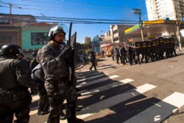 Miembros de la Policía brasileña dispersan a un grupo de manifestantes, durante la primera protesta contra el Mundial de fútbol Brasil 2014 registrada en Sao Paulo (Brasil), en el día en que comienza la competición. Cerca de 150 hombres de la Tropa de Choque de la Policía Militarizada del estado de Sao Paulo dispersaron a un grupo de 50 manifestantes que intentaba marchar por la avenida Radial Este, la principal vía de acceso al Arena Corinthians, el estadio de Sao Paulo en que se disputará el partido inaugural del Mundial.