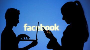 FILE PHOTO: People are silhouetted as they pose with laptops in front of a screen projected with a Facebook logo, in this picture illustration taken in Zenica October 29, 2014. REUTERS/Dado Ruvic/File Photo