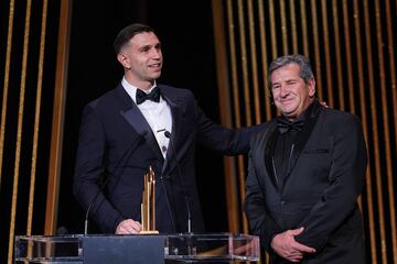 El portero del Aston Villa, Emiliano Martínez, recibe en el escenario el trofeo Yachine al mejor portero del mundo junto a su padre Alberto Martínez durante la ceremonia de entrega del Balón de Oro de Fútbol de Francia 2023