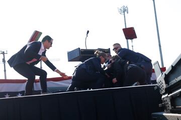 El expresidente, Donal Trump, es evacuado por el servicio secreto del estrado, con algo de sangre en el rostro, tras escucharse disparos. El candidato republicano ha salido por su propio pie con el pu?o en alto.