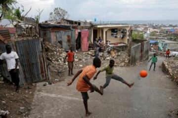 Varios niños juegan en las calles de Haiti devastadoas por el huracán Matthew.