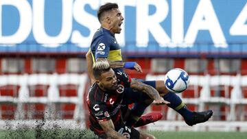 Tijuana's Julian Velazquez, below, collides with Boca Juniors's Carlos Tevez during the first half of a friendly soccer match Wednesday, July 10, 2019, in Tijuana, Mexico. (AP Photo/Gregory Bull)