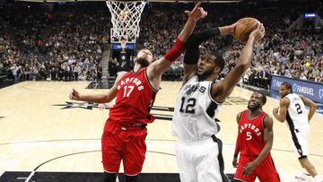 Jan 3, 2017; San Antonio, TX, USA; San Antonio Spurs forward LaMarcus Aldridge (12) grabs a rebound as Toronto Raptors center Jonas Valanciunas (17) defends during the second half at AT&T Center. The Spurs won 110-82. Mandatory Credit: Soobum Im-USA TODAY Sports