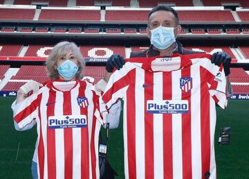 Dos aficionados posan con la camiseta del Atlético.