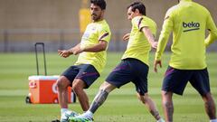 BARCELONA, SPAIN - MAY 25: In this handout provided by FC Barcelona Luis Suarez (L) of FC Barcelona plays the ball with his teammate Lionel Messi (R) during a training session  on May 25, 2020 in Barcelona, Spain. Spanish LaLiga clubs are back training in