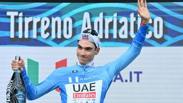 Juan Ayuso sonríe en el podio de Tirreno con la maglia azzurra de líder.