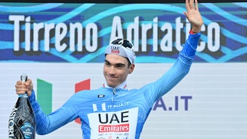 Juan Ayuso sonríe en el podio de Tirreno con la maglia azzurra de líder.