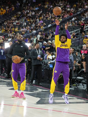 Padre e hijo se divierten durante el calentamiento previo al partido de pretemporada de la NBA entre Golden State Warriors y Los Angeles Lakers.