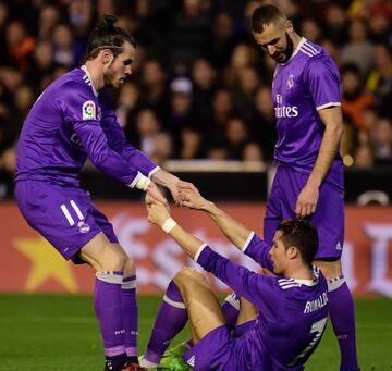 Real Madrid's Welsh forward Gareth Bale (L) and Real Madrid's French forward Karim Benzema help-up Real Madrid's Portuguese forward Cristiano Ronaldo during the Spanish league football match