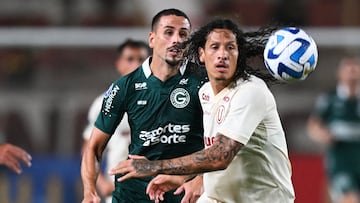 Goias' forward Matheus Peixoto (L) and Universitario's Paraguayan defender Williams Riveros vie for the ball during the Copa Sudamericana group stage first leg football match between Universitario and Goias at the Monumental stadium in Lima on April 20, 2023. (Photo by ERNESTO BENAVIDES / AFP)