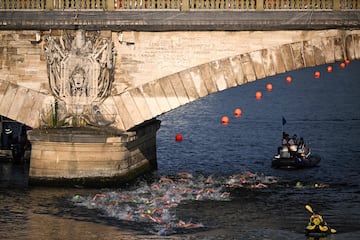 (FILES) Triathlon athletes swim in the Seine river during the men's 2023 World Triathlon Olympic Games Test Event in Paris, on August 18, 2023. It must shine, and make Paris and the athletes shine: but the Seine, expected star of the 2024 Olympics as the site of the opening ceremony and open water events, is suffering from unpleasant weather which is giving cold sweats to the organizers. (Photo by Emmanuel DUNAND / AFP)