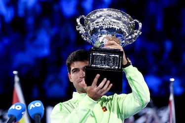 El español Carlos Alcaraz celebra con el trofeo tras ganar al serbio Novak Djokovic en su partido final individual masculino en el día quince del torneo de tenis Abierto de Australia en Melbourne.