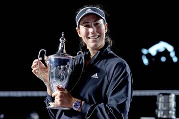 Garbñe Muguruza sosteniendo el trofeo de las WTA Finals.