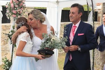 El recién estrenado matrimonio besa a su hija Alexia, encargada de llevar los anillos.