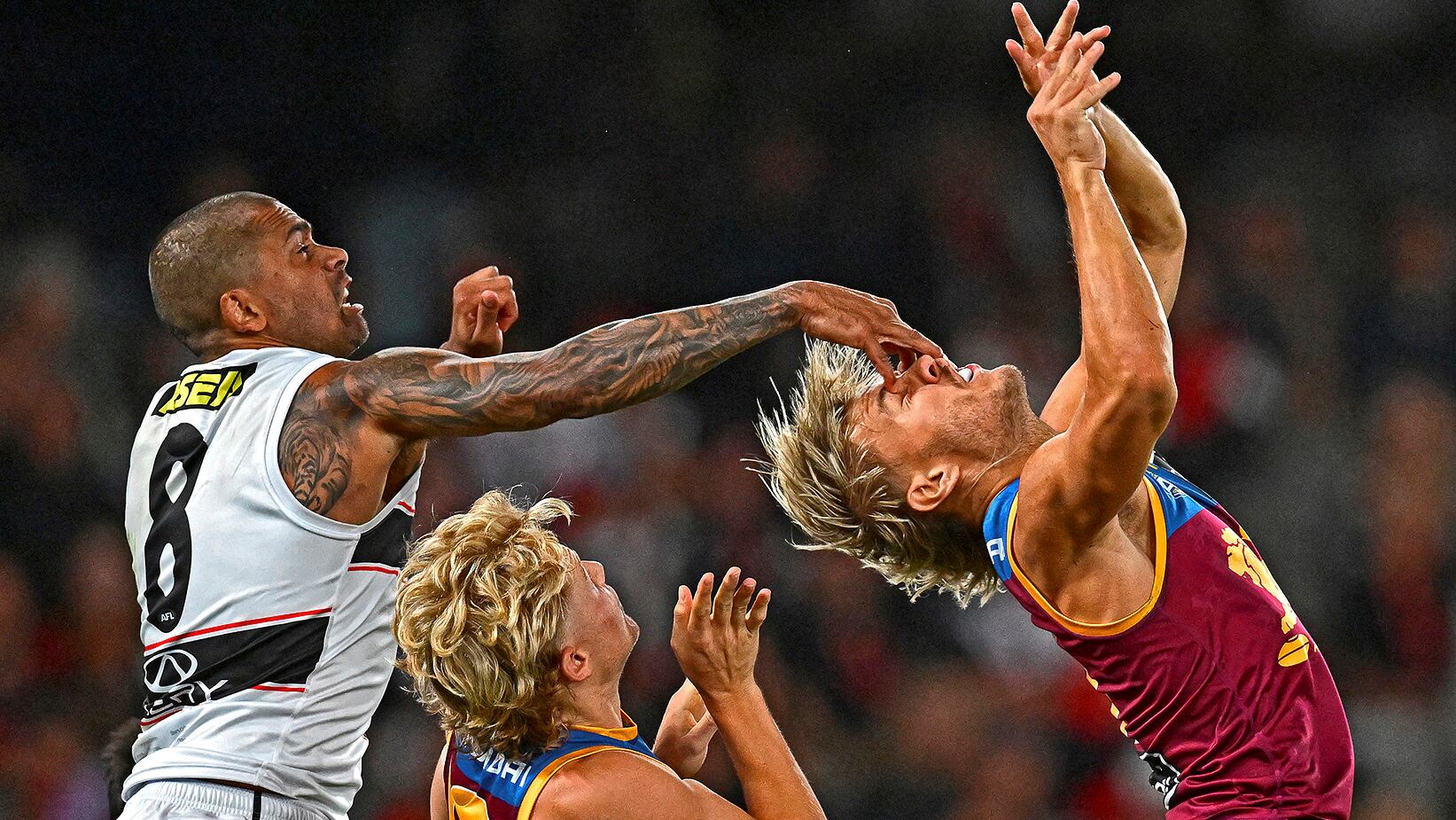 Bradley Hill de St. Gilda's Saints, durante la Australian Football League (AFL), cubre los ojos del equipo de Brisbane Lions con su mano, en una forma inusual de neutralización del competidor. Esta variación de fútbol se enfrenta a los dos equipos de 18 jugadores y se juega con una pelota rociada en el campo ovalado.